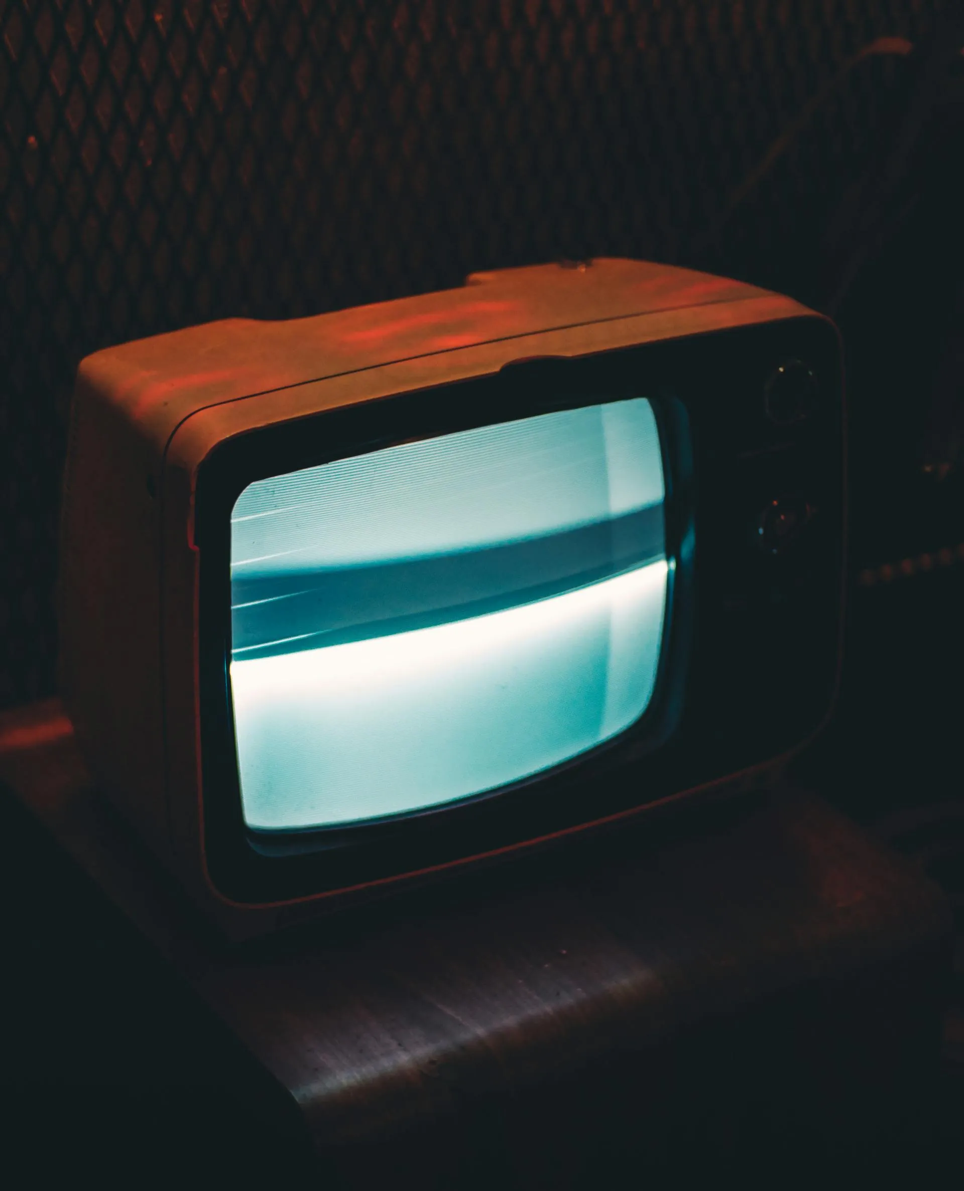 Free A vintage television glowing in a dark, retro ambiance.